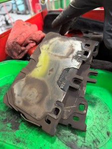 Worn Mercedes-AMG brake pad showing heat discoloration on the backing plate