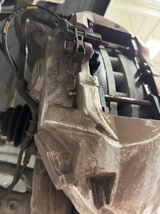AMG caliper piston, pad wear sensor wiring and mounting hardware during disassembly